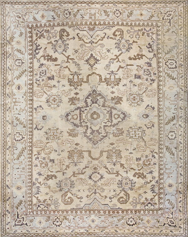 Cream rug featuring a traditional, intricate pattern and borders in taupe and muted blue-gray colors.