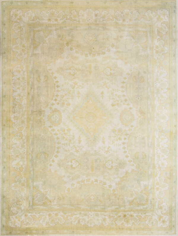 Distressed traditional rug in light cream and faded yellow features a large central medallion and borders.