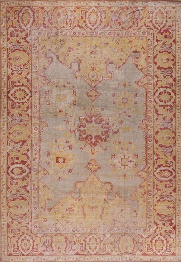 Traditional rug featuring a faded gray field, bordered by intricate patterns in deep red and distressed yellow.