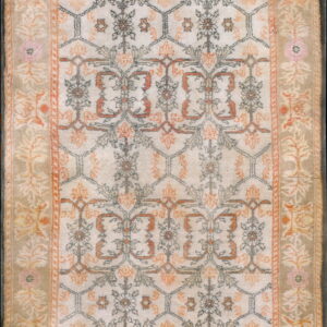 Cream and orange traditional rug with a detailed central trellis pattern and a wide tan floral border.