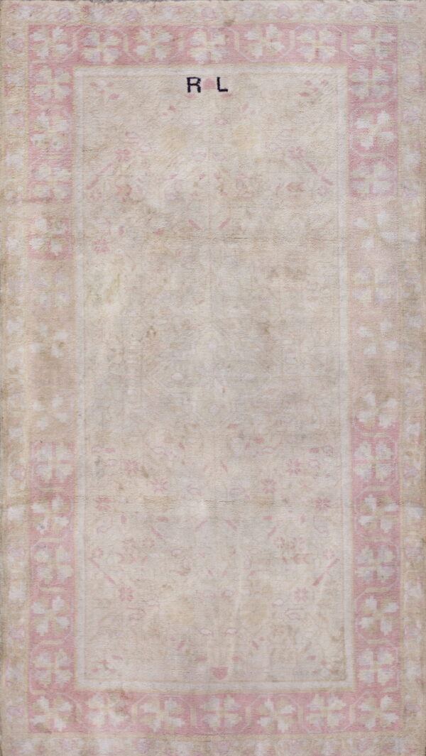 Faded beige rug featuring a subtle central pattern and a wide pale pink floral repeating border.
