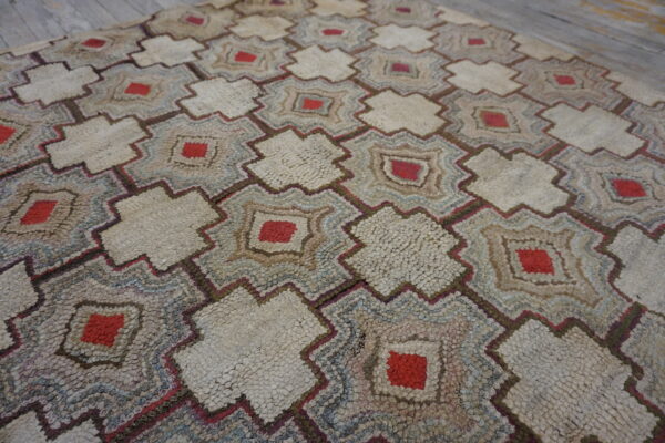 Shaggy rug showing repeating cream, red, blue, and brown geometric star patterns on a wood floor.