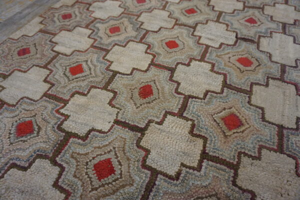 Nubby, low-pile rug featuring interlocking geometric patterns in cream, red, brown, and blue.