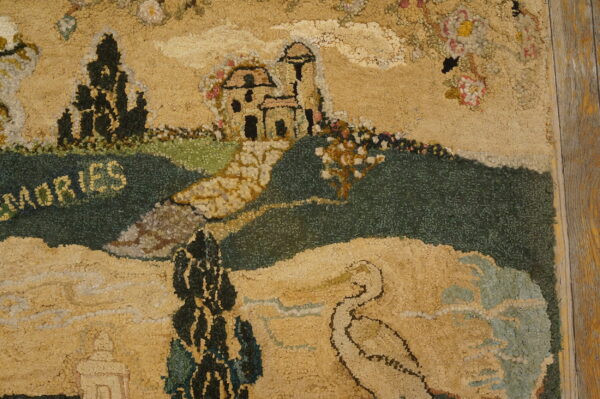 Hooked rug detailed with tan and green hills, a castle, and the word "memories" on wooden flooring.