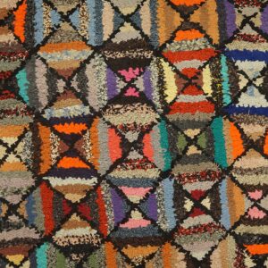 Shaggy, high-pile rug detail showing a lattice of triangles in bright, varied colors and textures.