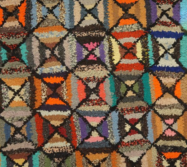 Shaggy, high-pile rug detail showing a lattice of triangles in bright, varied colors and textures.