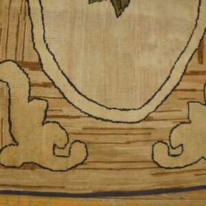 Tan and brown looped-pile rug detail showing bold outlined figures and striped texture on wood planks.