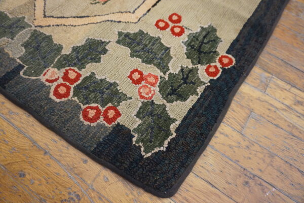 Hooked rug corner featuring green holly and red berries rests on distressed hardwood planks.