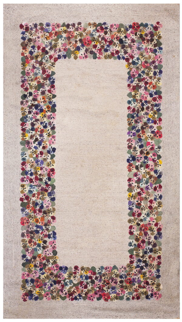 Off-white textured rug with a thick border of densely packed multicolored flowers.