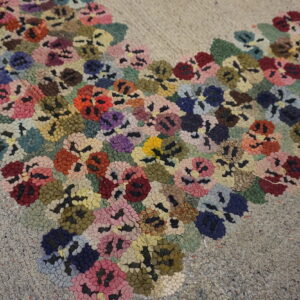 Textured high-pile rug with dense clusters of red, pink, blue, and yellow flowers on a gray speckled ground.