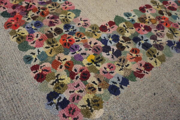 Textured high-pile rug with dense clusters of red, pink, blue, and yellow flowers on a gray speckled ground.