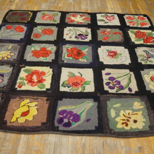 Multicolored patchwork rug with floral and bird designs in chunky texture, displayed on distressed hardwood flooring.