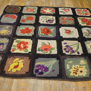 Hooked rug with multicolored floral and bird squares separated by a dark grid on wood floors.