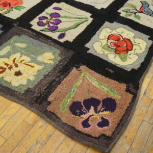 Textured rug with multi-colored floral and bird blocks framed in black on rustic light wood planks.