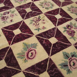 High-pile rug with a checkered design alternating cream floral squares and textured burgundy diamond patterns.