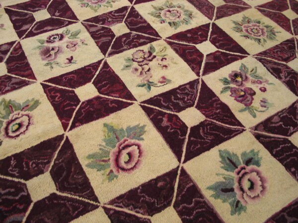 High-pile rug with a checkered design alternating cream floral squares and textured burgundy diamond patterns.