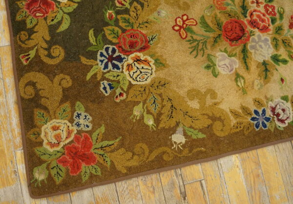 Detailed high-pile rug with red, blue, and gold scrolling florals on a tonal brown background over aged wood floors.