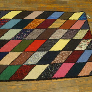 Multicolored high-pile rug featuring a diamond geometric pattern resting on distressed yellow wood planks.