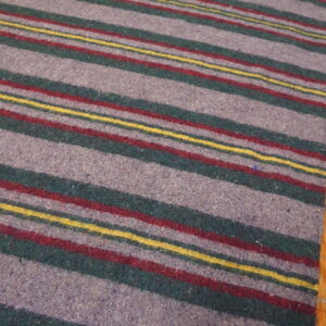 Low-pile gray rug featuring horizontal stripes of green, red, and yellow on wood flooring.