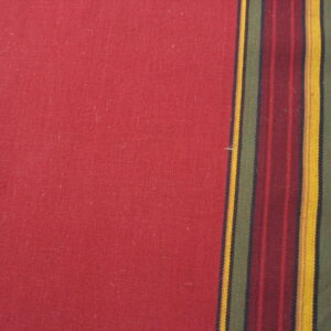 Red flatweave rug surface with a multicolored vertical stripe border next to worn brown wood.