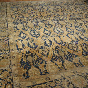 Ornate indigo and tan rug featuring complex repeating patterns on a hardwood floor.