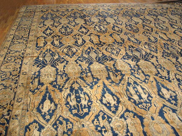 Ornate indigo and gold rug featuring complex repeating patterns and stylized figures on wood floors.