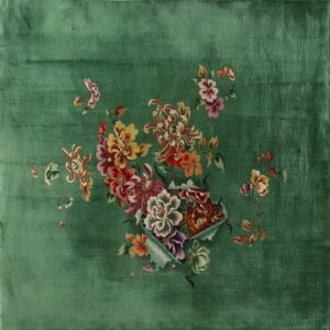 Velvety green rug featuring a central spray of multi-colored flowers in red, gold, pink, and purple.