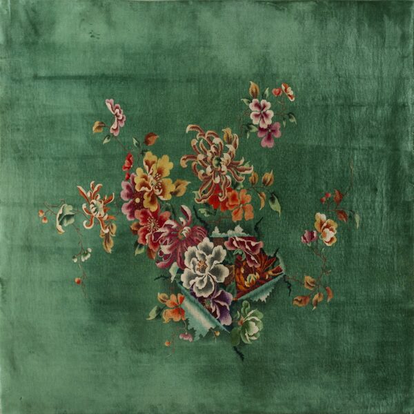 Velvety green rug featuring a central spray of multi-colored flowers in red, gold, pink, and purple.