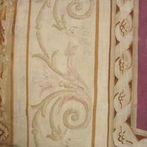 Flatweave rug detail featuring wide cream and burgundy borders with scrolling beige botanical motifs.
