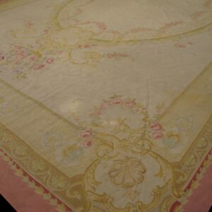 Ornate cream rug featuring pink rose bouquets, gold scrolls, and a wide dusky pink outer border.