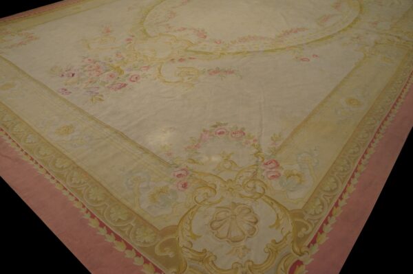 Ornate cream rug featuring pink rose bouquets, gold scrolls, and a wide dusky pink outer border.