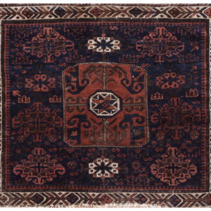 Square geometric rug in deep navy and rust red with a central medallion and complex geometric borders.
