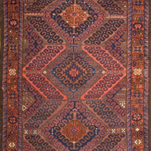 Rectangular low pile rug featuring nested geometric diamonds in mahogany, indigo, and coral colors.