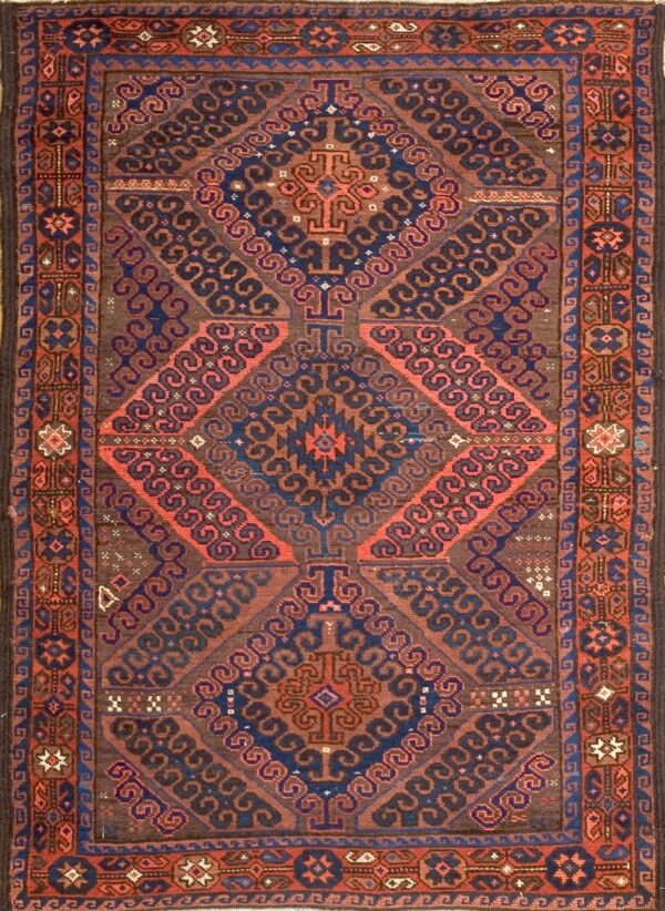 Rectangular low pile rug featuring nested geometric diamonds in mahogany, indigo, and coral colors.