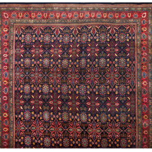 Dark blue traditional rug with a detailed repeating floral pattern and wide multi-banded red border.