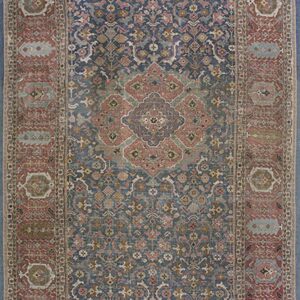 Runner rug with a blue central field, a prominent medallion, and densely patterned red borders.