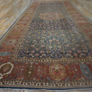 A long patterned rug, featuring deep blue and rust colors, rests on wide, distressed wood planks.