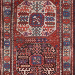 Red and navy tribal rug with ivory and dark geometric center medallions and patterned borders.