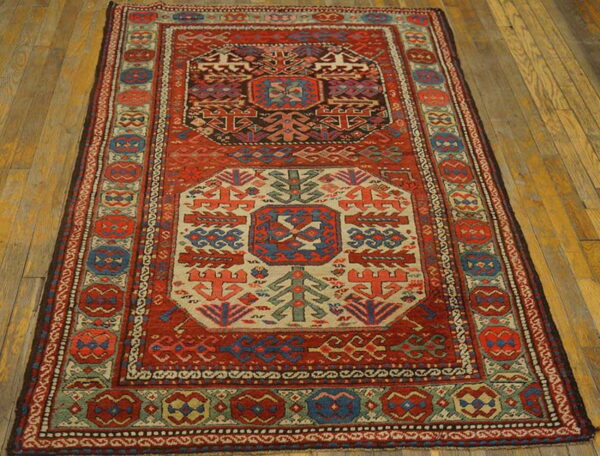 Rust red runner rug with geometric blue and cream medallions rests on wide plank wooden floorboards.