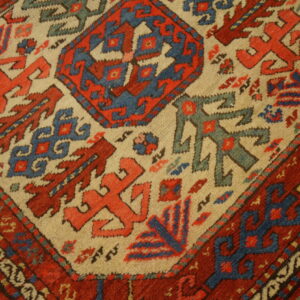 Thick pile rug featuring high-contrast geometric tribal patterns in deep red, blue, and light tan.