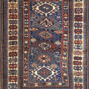 Traditional rug with a navy blue field, stacked geometric medallions, and wide ivory borders featuring red and blue motifs.