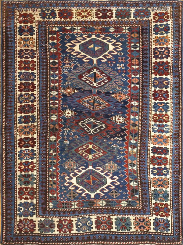 Traditional rug with a navy blue field, stacked geometric medallions, and wide ivory borders featuring red and blue motifs.
