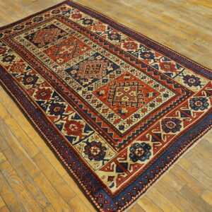 Rectangular rug featuring geometric panels in rust, navy, and cream on natural wooden planks.