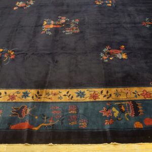 High-pile dark blue rug featuring scattered pictorials and detailed floral borders on a wood floor.