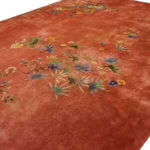 Rust-toned rug with subtle carving and scattered multicolored botanical and floral designs.