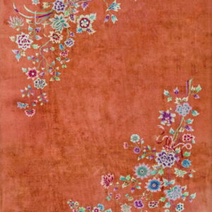 High-pile rust rug with asymmetrical bouquets of purple, blue, and green flowers in the corners.