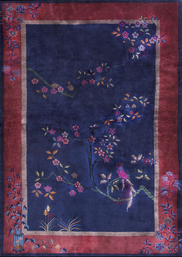 Plush navy rug displaying an ornate floral and bird motif surrounded by a wide burgundy border.