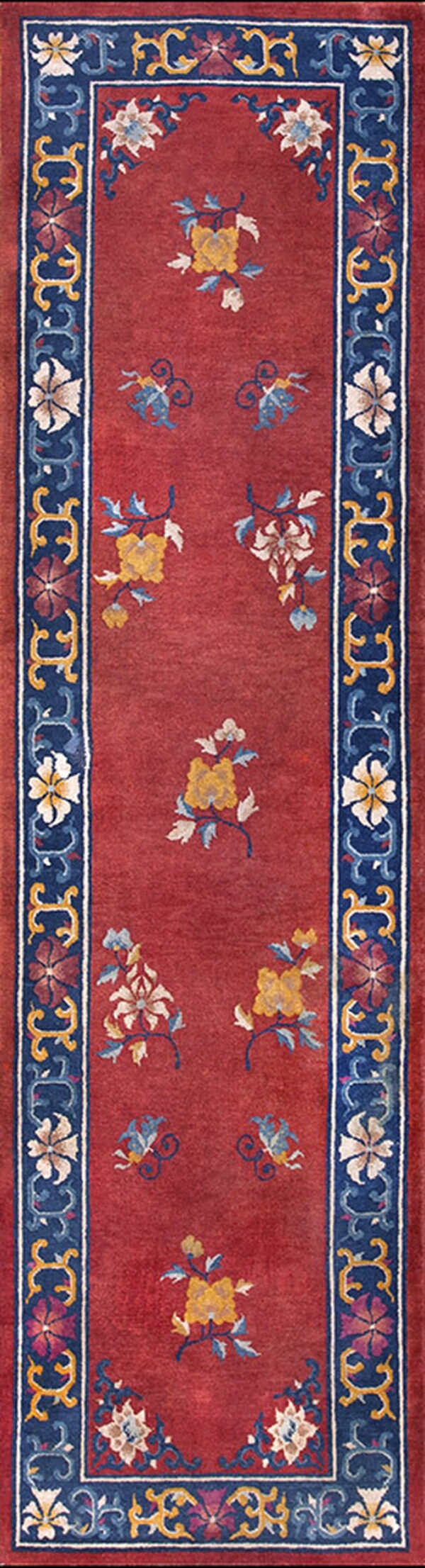 Red runner rug with a scattered floral pattern and a wide dark blue, yellow, and red decorative border.