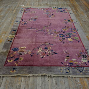 Mauve rug with colorful floral vines and a wide gray border on distressed wood plank flooring.