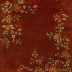 Rust-colored rug featuring a detailed border of muted yellow, green, and pink flowering vines.